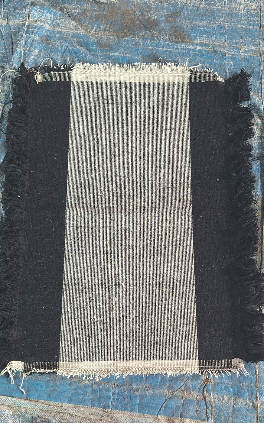 A wool rug with a charcoal border and a grey ribbed centre panel