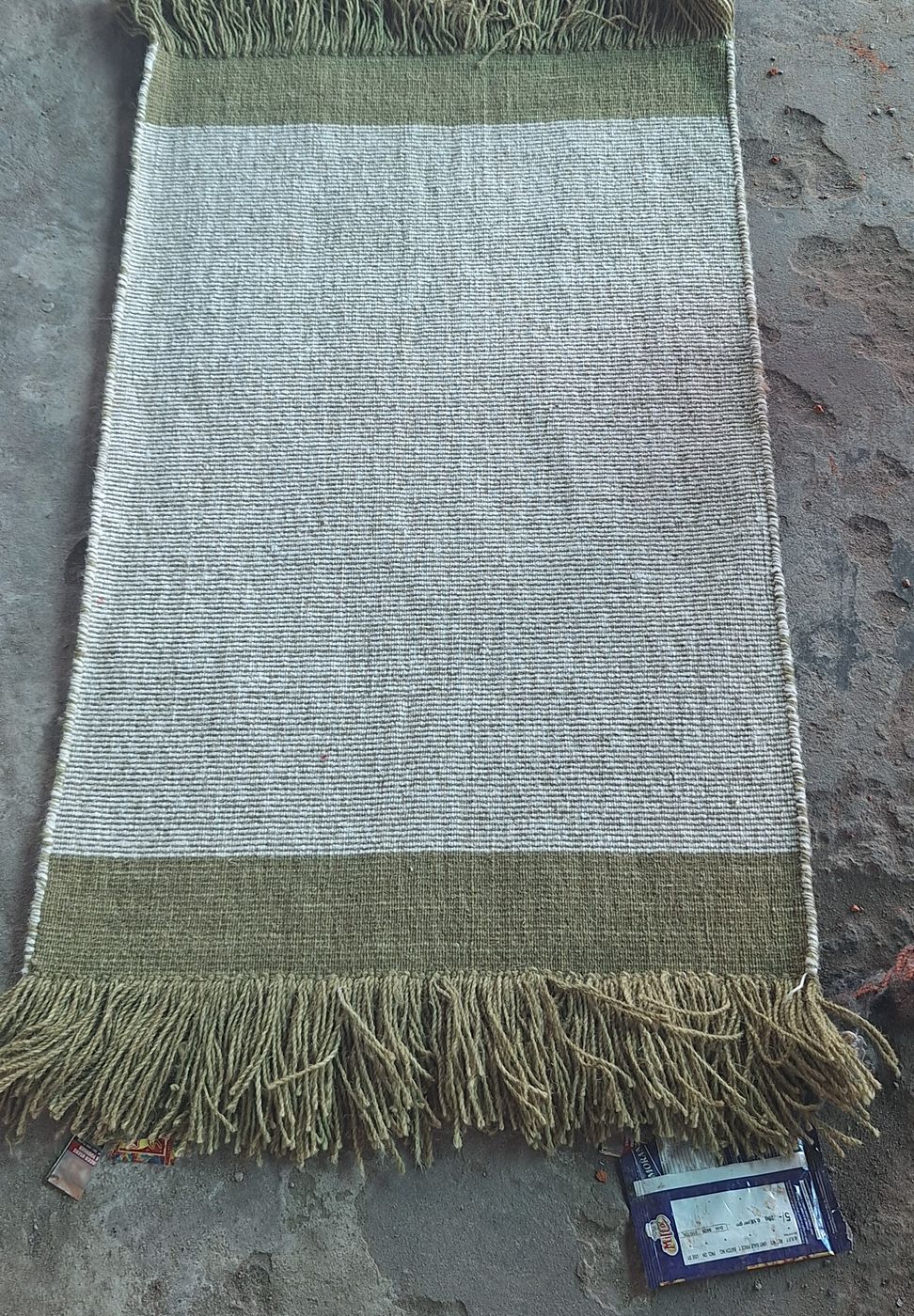 A wool flatweave runner with olive end bands and long fringe