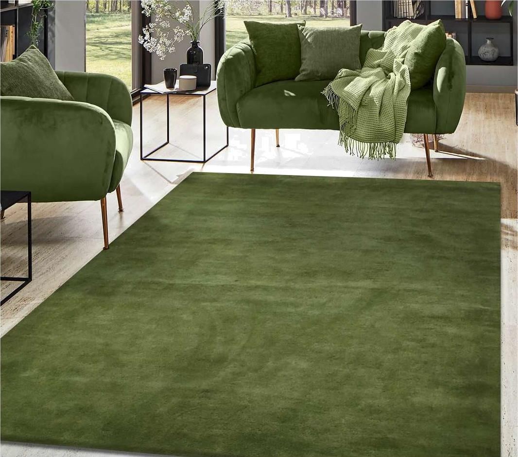 A solid olive wool rug laid across a bright sitting room