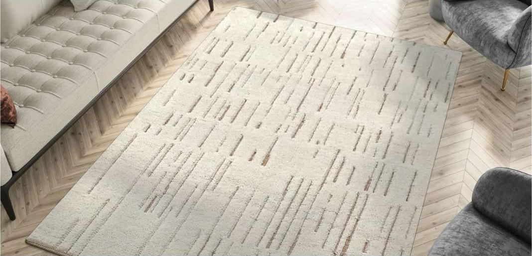An ivory hand-knotted rug laid in a furnished room