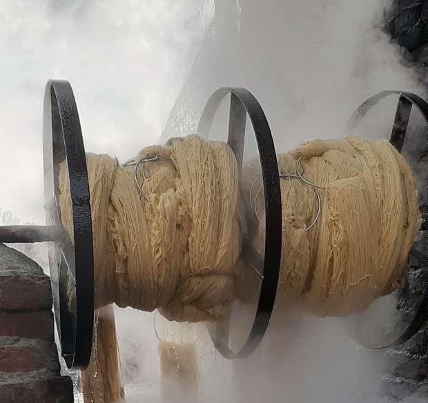 Skeins of wool yarn turning on a steaming dye drum